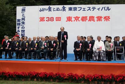 東京都農業祭の開会式で祝辞を述べる中川雅治（立っている人）